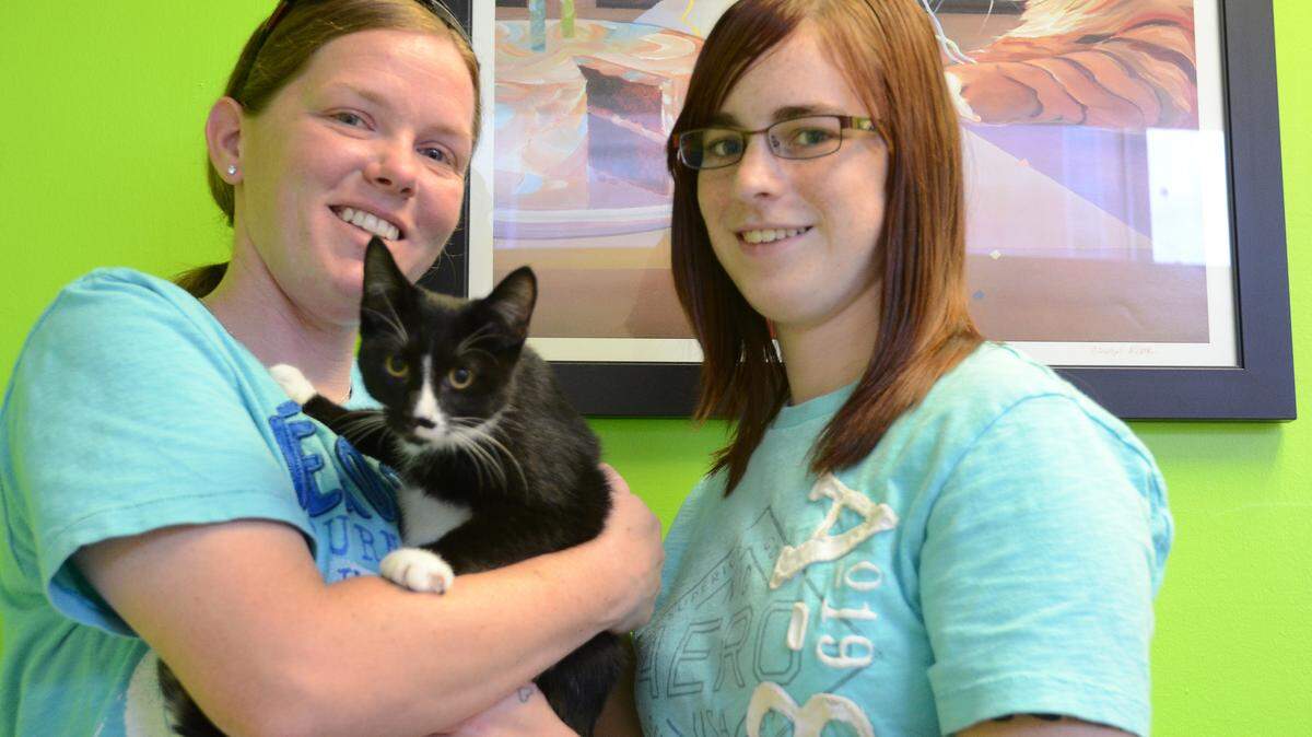 Caitlyn Simpson and Brandy Akins with a 5-month-old kitten named Scooper, who they adopted Thursday. Scooper was the 200th cat adopted from Downtown Meowtown. 
 PHOTO PROVIDED