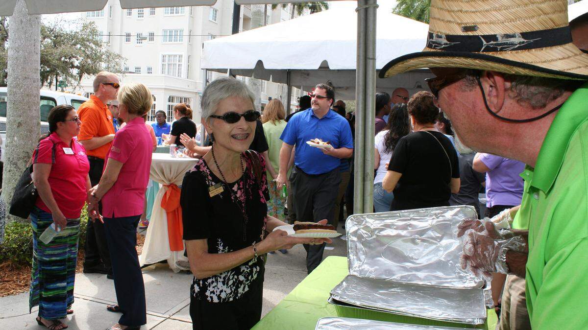 John Rice serves up a hot dog to Sandra Stone, the regional chancelor for the University of South Florida Sarasota-Manatee at the Manatee Chamber of Commerce's second annual member appreciation cookout Friday in Bradenton. Rice, who owns Rice's Appliance & TV, was part of a group of chamber volunteers who grilled hot dogs and served food for the lunchtime event. The cookout attracted over 400 people. 
 PROVIDED PHOTO