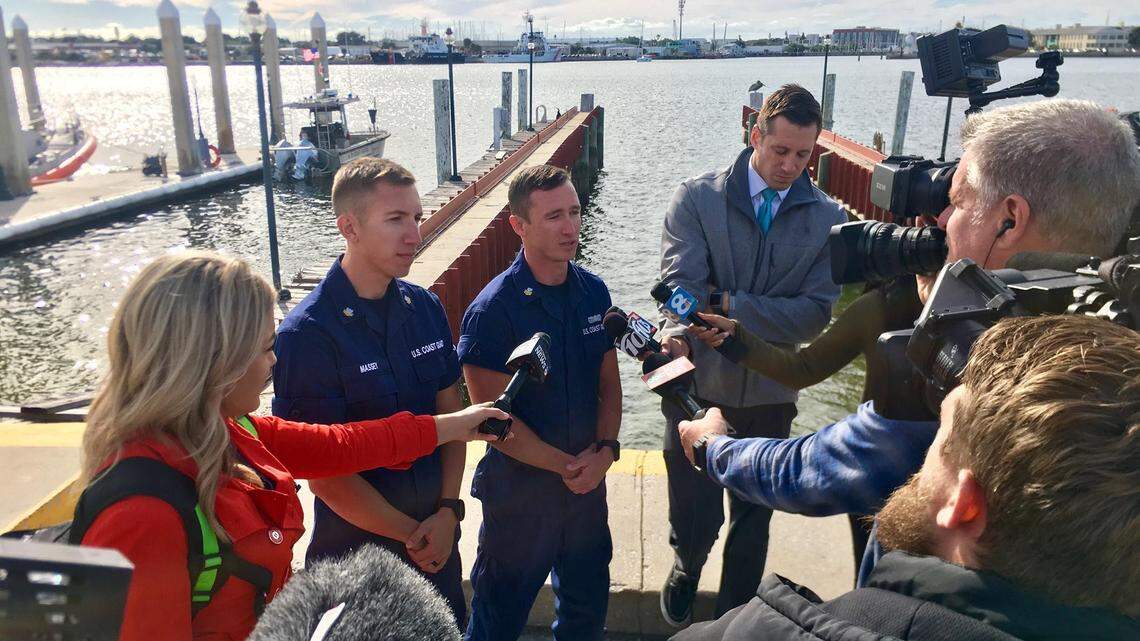 U.S. Coast Guard members talk to the media after assisting in a rescue after a plane landed in the waters of Tampa Bay by Albert Whitted Airport in St. Petersburg.