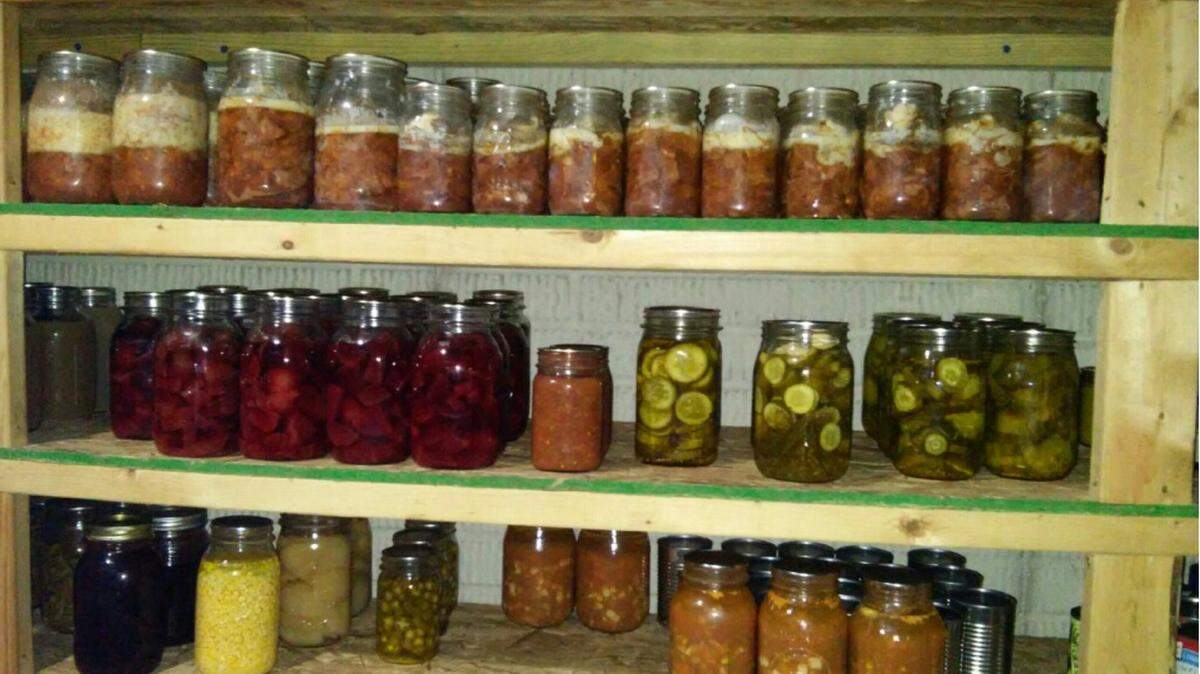 Lovina Eicher and daughter Susan tackled the big job of cleaning the can room in their basement where they have shelves storing their canned food.