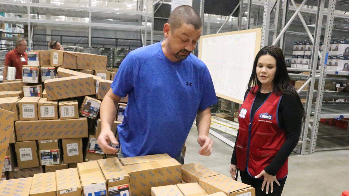 Brittany Wagner, store manager of Lowes of Parrish, stops by scan central as merchandise arrives at the store on Nov. 17, 2022. Also shown is Doug Stevenson.