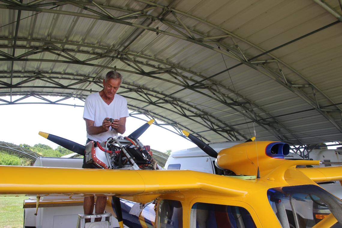 Ed Sweeney works on the starter assembly of his Russian-made twin-engine aircraft at Airport Manatee.