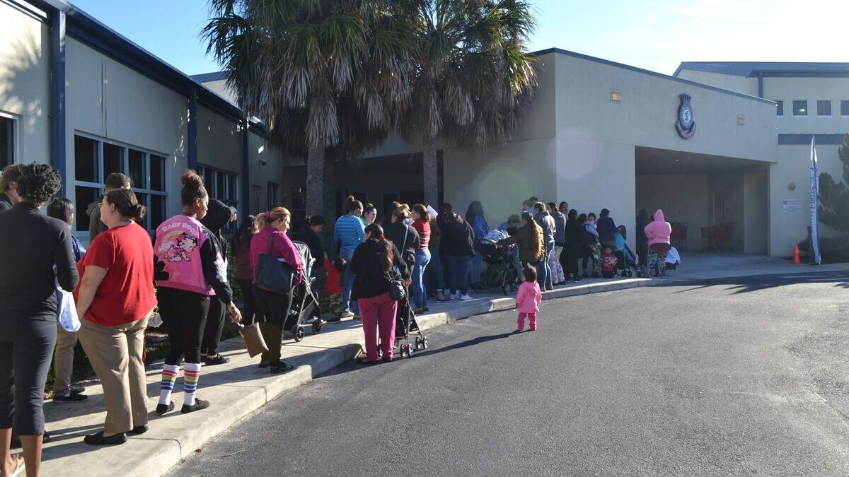 Parents line up to pick up Christmas gifts for their kids outside of Salvation Army of Manatee County on Tuesday.