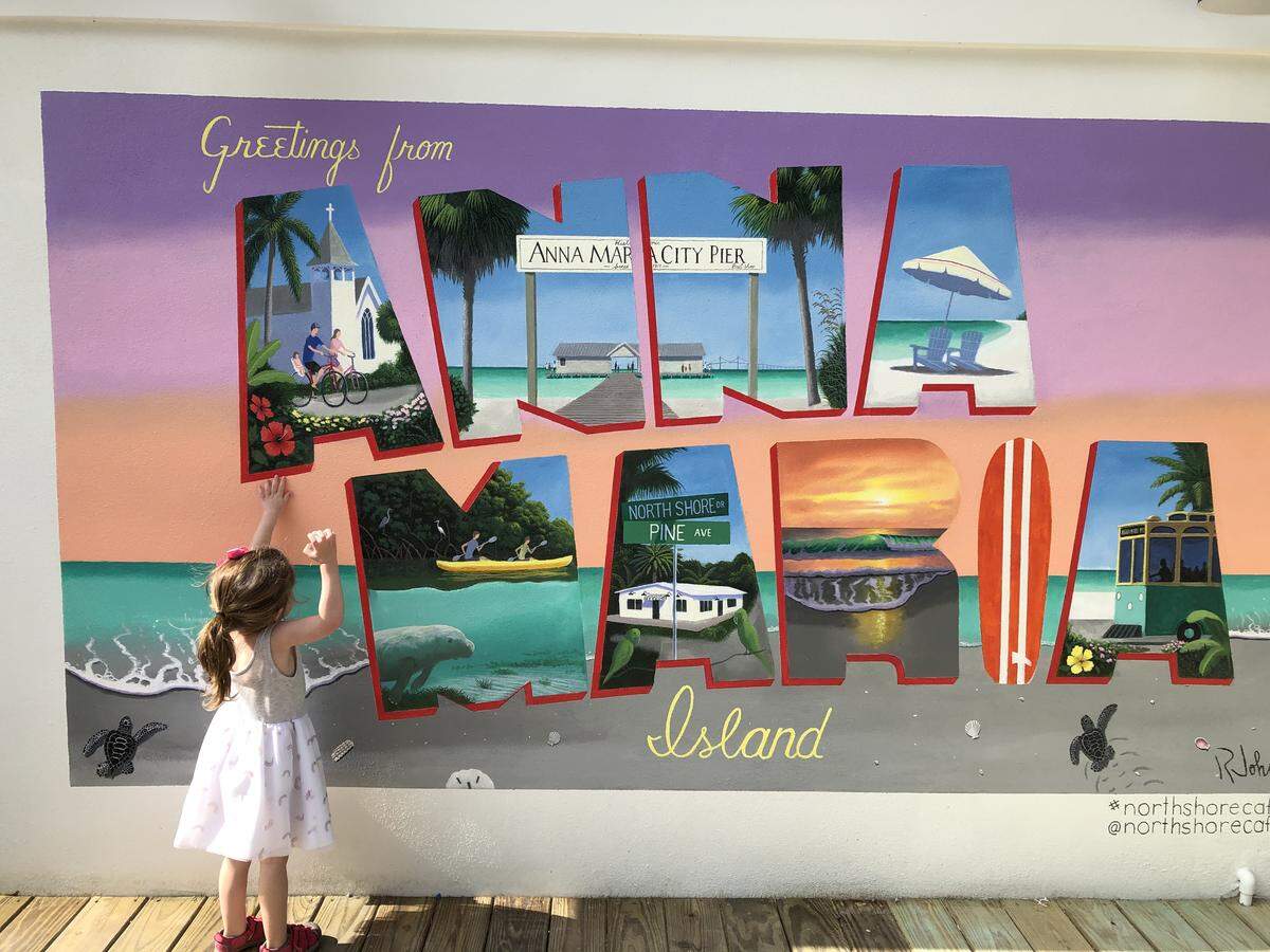 Vivian Rose Geller points to her image on an Anna Maria Island mural at North Shore Cafe, 304 Pine Ave. The restaurant recently opened in Anna Maria. Vivian Rose is shown in the bike and church scene.