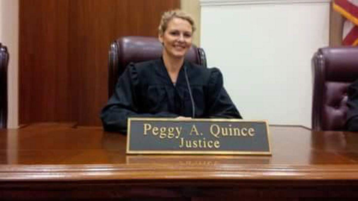 Sarah Boler, a Manatee High School teacher, poses for a photo in Justice Peggy Quince's seat. PHOTO PROVIDED