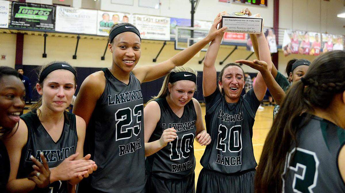 Elise Spiller (20) holds their trophy and celebrates with teammates. The Lakewood Ranch Lady Mustangs defeated the Lady Hurricanes from Palm Harbor University High School 49-42 to claim the Class 7A Region 3 Championship at Palm Harbor University High School on Friday evening February 12, 2016. The Lady Mustangs will advance to the State Final Four next week.DAVID W DOONAN | Special To The Herald