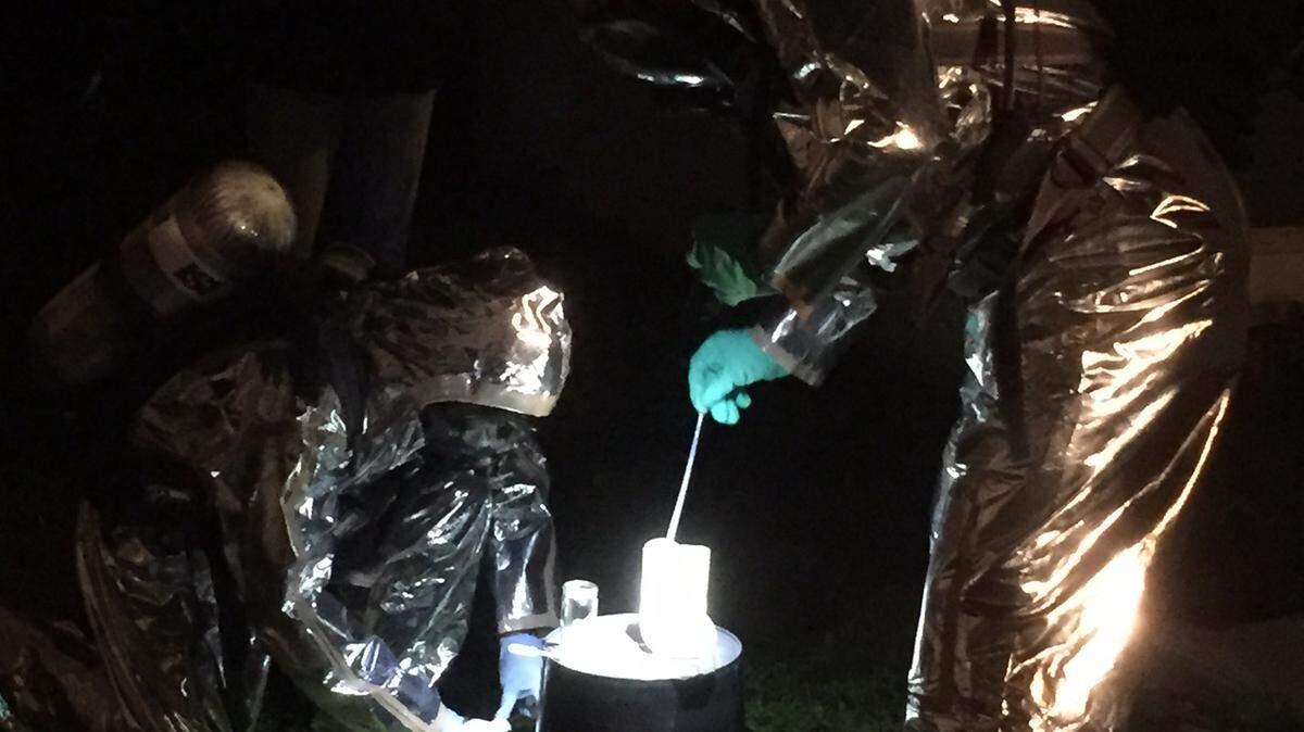 Sarasota sheriff's detectives dressed in protective gear test suspicious liquid for the presence of methamphetamine before transferring the substance into evidence jars. 
 PHOTO PROVIDED.