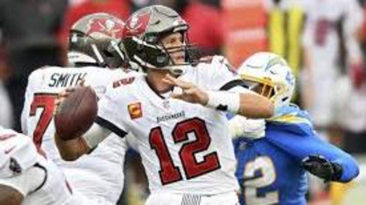 Tampa Bay Buccaneers quarterback Tom Brady eludes Chargers linebacker Uchenna Nwosu as he throws during the first half on Sunday.