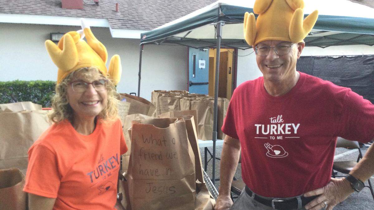 Tami and Don Goudy get in the spirit at Saturday’s drive-thru food pantry that included everything a family needed to put together a big Thanksgiving feast. They were among a small army of volunteers helping to serve about 500 families thanks to the Parrish United Methodist Church.