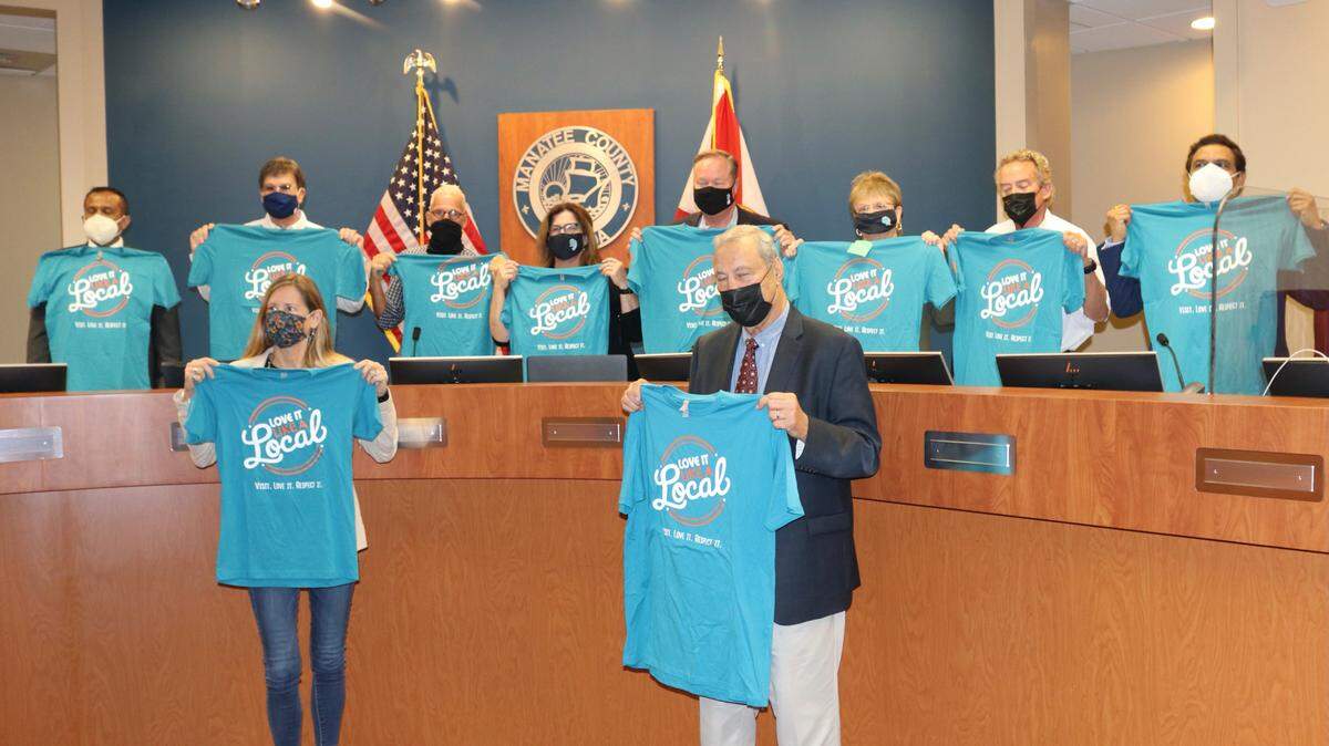 4/19/2021--Members of the Manatee County Tourist Development Council and Manatee County mayors hold up “Love It Like a Local” T-shirts. The marketing campaign aims to educate visitors on the importance of safeguarding the local environment.