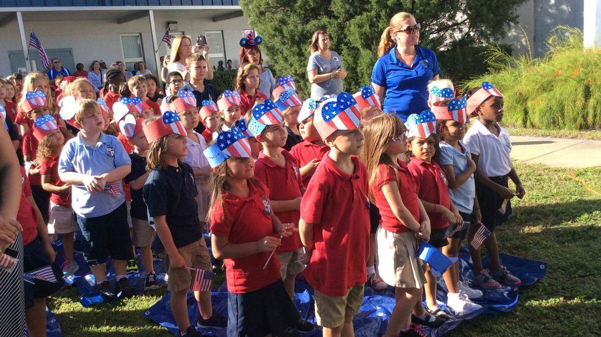 Rowlett Academy for Arts and Communication students stand for the Pledge of Allegiance in the school courtyard on Friday as part of the school's annual celebration. MEGHIN DELANEY / Bradenton Herald