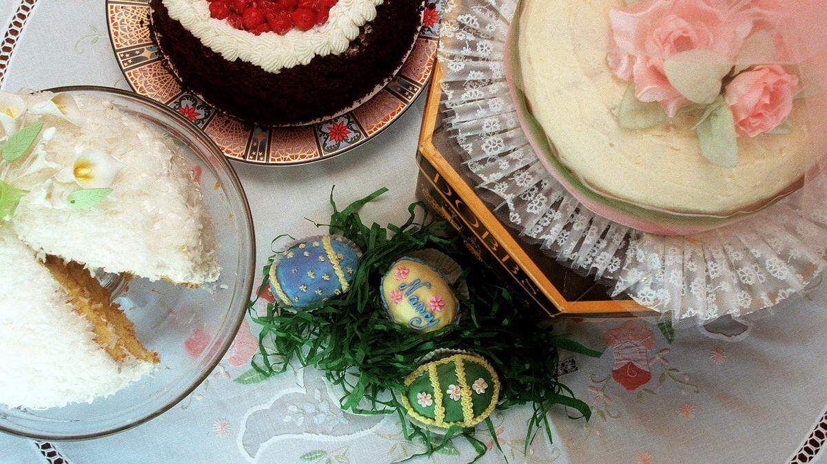 Cake arrangements from left to right, a lemon coconut cake with lemon filling, a cherry chocolate cake, Easter egg cupcakes and a pumpkin hat cake with butter creme icing.