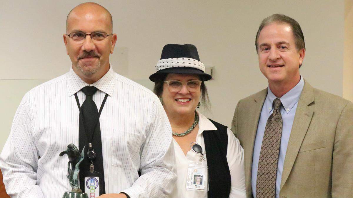 10/18/2021--Carmine DeMilio, Manatee County park operations manager, left, received the first-ever Outstanding Contribution to Tourism Award for his role in managing the clean-up of Manatee County beaches and waterways from dead sea life washed ashore by red tide. Also shown are Misty Servia, chair of the Manatee County Tourist Development Council, and Elliott Falcione, executive director of the Bradenton Area Convention and Visitors Bureau.