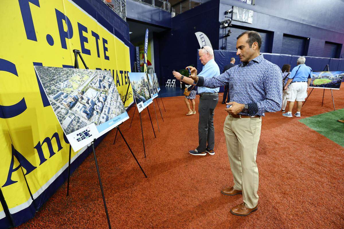 People take photos of the rendering of new Tampa Bay Rays ballpark at Tropicana Field.