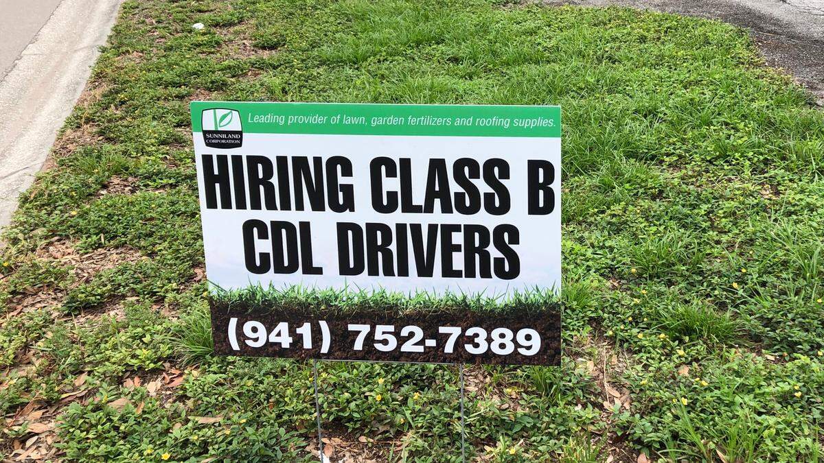 Sign posted in a Bradenton area industrial park advertises the need for drivers.