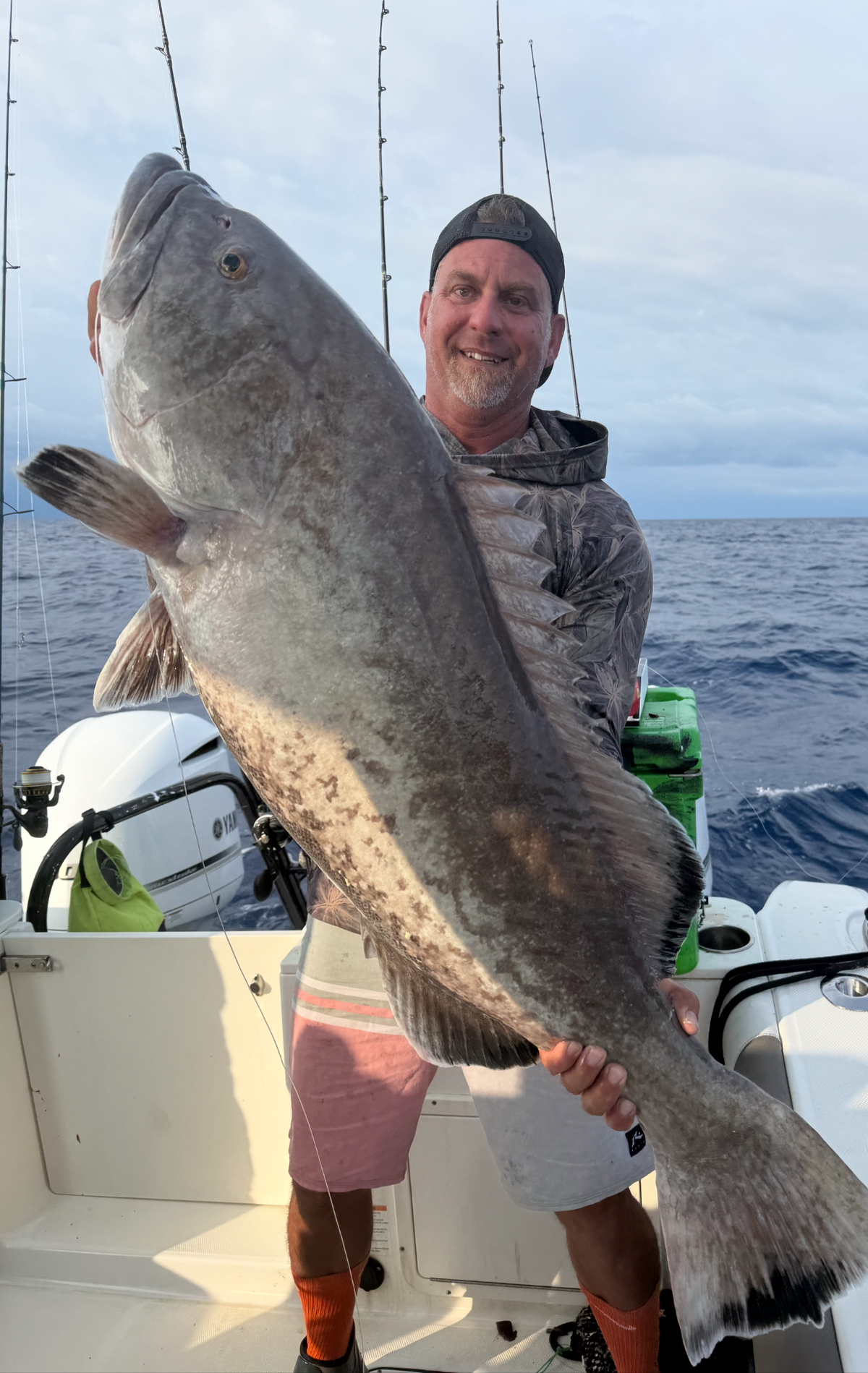 Captain John Gunter poses with a gag grouper caught fishing overnight last weekend before being caught offshore by storms.