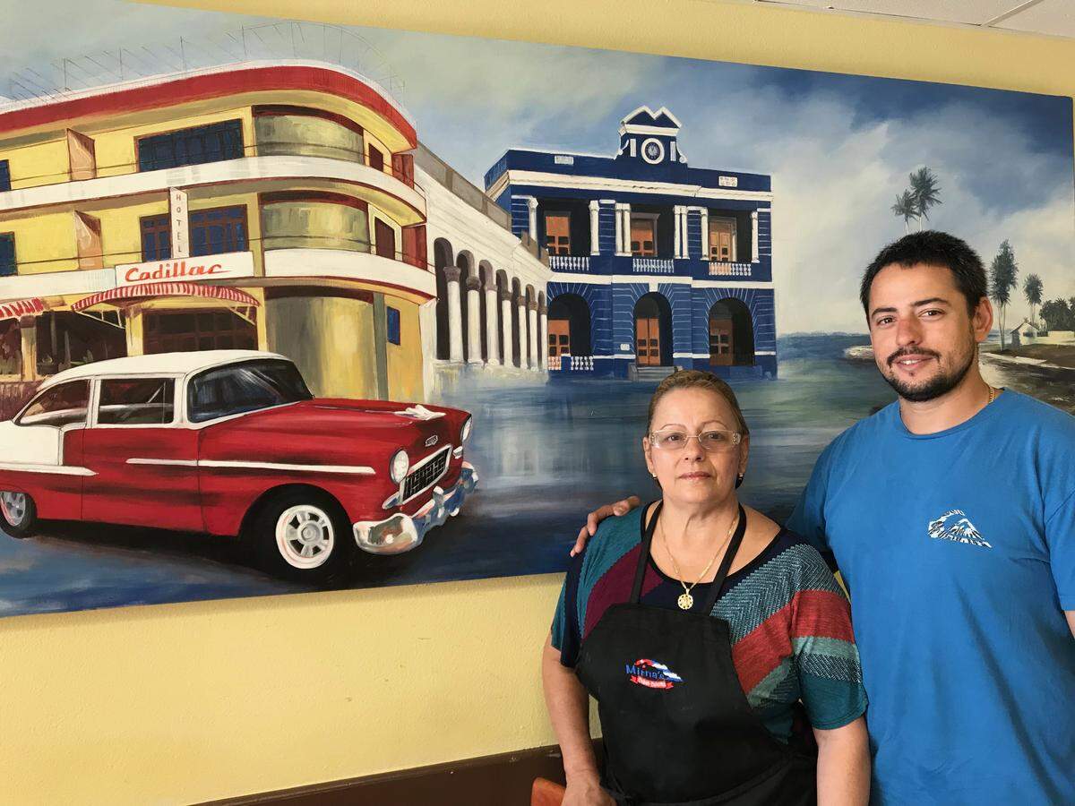 Mirna Gonzalez and her son David are attracting a growing number of diners to their restaurant, Mirna's Cuban Cuisine, at 7980 N. Tamiami Trail, near Sarasota Bradenton International Airport. They are standing in front of a street scene from their native Las Tunas, Cuba.