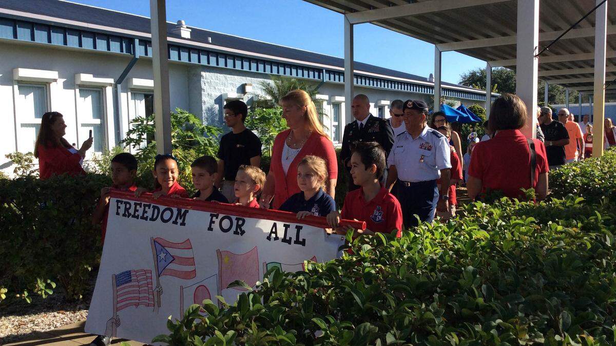 Rowlett Academy for Arts and Communication students lead a parade of veterans through the school courtyard on Friday as part of the school's annual celebration. MEGHIN DELANEY / Bradenton Herald