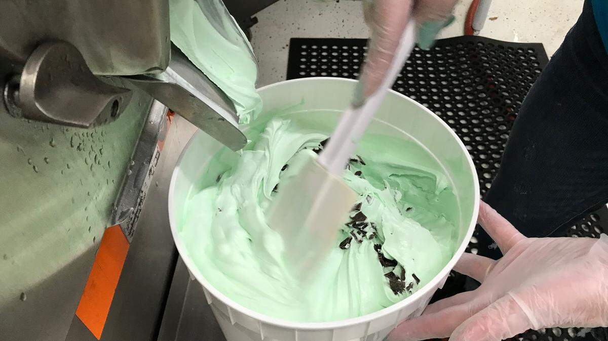 Chocolate chips are poured into the mint ice cream Thursday at the Lickity Splits plant. Several different flavors were being made and poured into 2 1/2 gallon tubs.