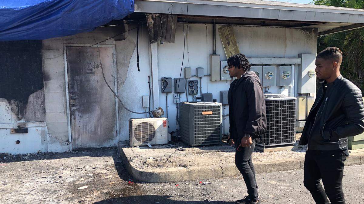 4/7/2021--Joe Morris, left, and Mikel Ervin survey damage from a kitchen fire that closed their HotBox Express Restaurant and several other businesses in Palmetto.
