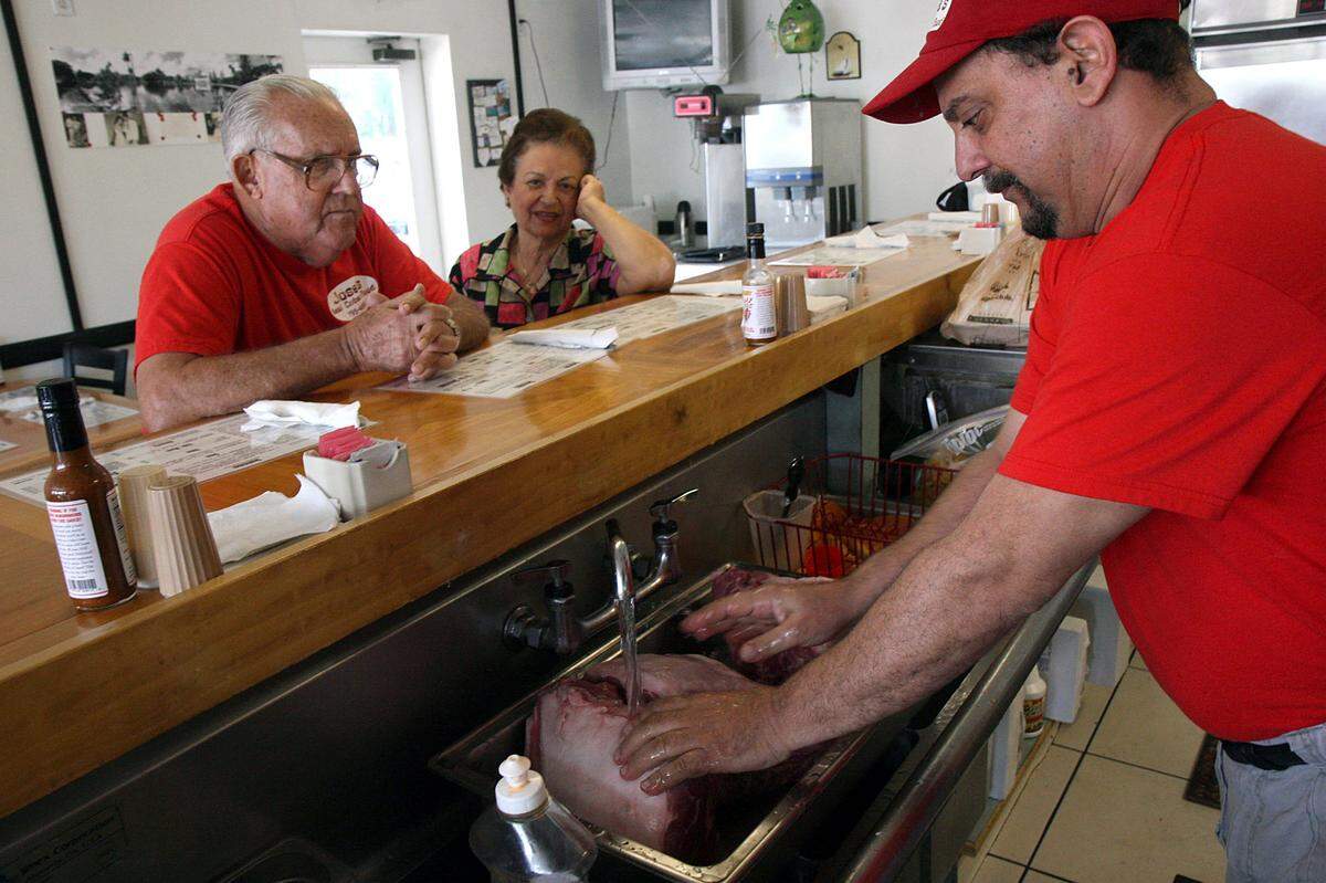 Jose Baserva prepares meat as his parents, Carlos and Hilda, watch at Jose’s Real Cuban Food on Cortez Road. Jose Baserva died Friday. -File PHOTO BY TIFFANY TOMPKINS-CONDIE/ttompkins@bradenton.com
