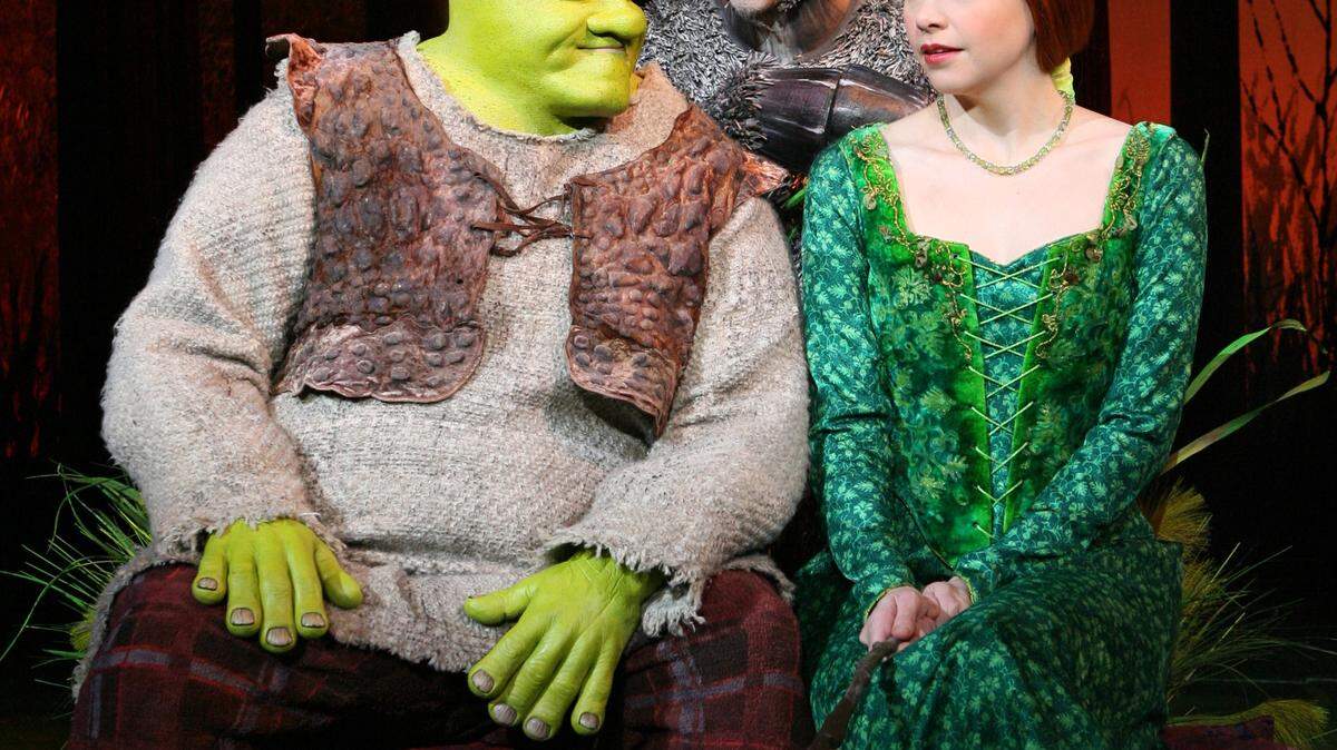 In this image released by Boneau/Bryan-Brown, Brian d'Arcy James is shown as the title character of Shrek, left, with Daniel Breaker as Donkey and Sutton Foster as Princess Fiona in "Shrek the Musical," now playing at the Broadway Theatre in New York. (AP Photo/Boneau/Bryan-Brown, Joan Marcus) ** NO SALES, MANDATORY CREDIT: Joan Marcus **
