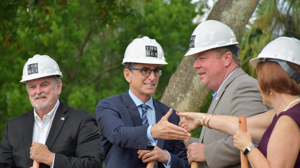 Marshall Gobuty, president of Pearl Homes, shakes hands with Councilwoman Marianne Barnebey after breaking ground on The Met, a 199-unit affordable housing complex in the Village of the Arts, on Tuesday morning.