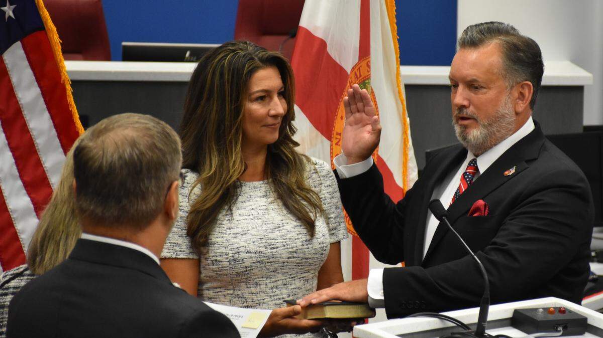 Manatee County Commissioner Mike Rahn lays his left hand on the Bible and raises his right hand as he is sworn into a 4-year term on the Board of County Commissioners on Nov. 22, 2022.