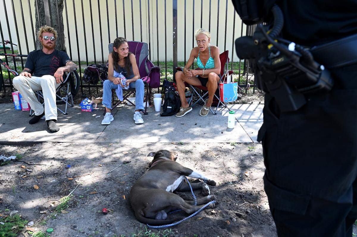 Bradenton police officer Jordan Poulos talks to people without housing on the street behind the Salvation Army; asking how they are and if he could help them in any way. One woman said she needed assistance filing a police report and obtaining identification, and another person expressed an interest in getting help with substance abuse. Poulos took notes and said he would work on their needs.