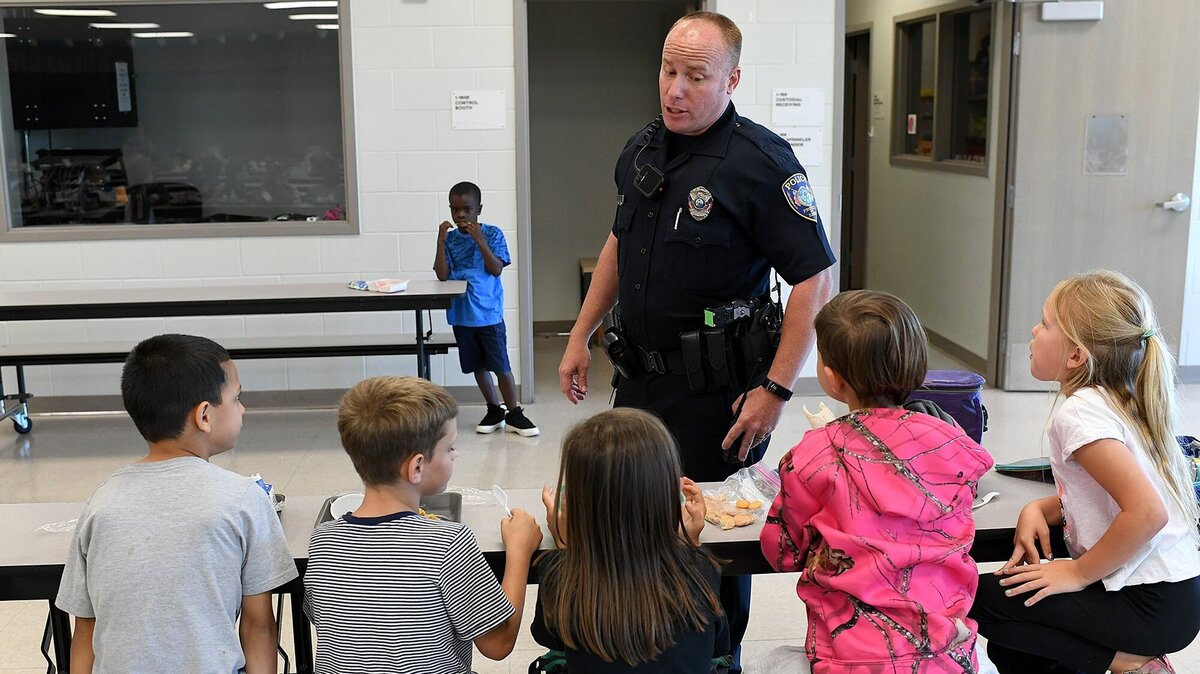 Bradenton Police officer Rusty Ackerman talks with students at lunch as he fills in as a school resource officer at Miller Elementary School last school year.