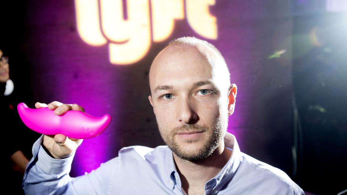 FILE - In this Monday, Jan. 26, 2015, file photo, Logan Green, co-founder and chief executive officer of Lyft, displays his company's "glowstache" during a launch event in San Francisco. On Monday, Jan. 4, 2016, General Motors Co. announced it is investing $500 million in ride-sharing company Lyft Inc. GM gets a seat on Lyftís board as part of the partnership, which could speed the development of on-demand, self-driving cars. (AP Photo/Noah Berger, File)
