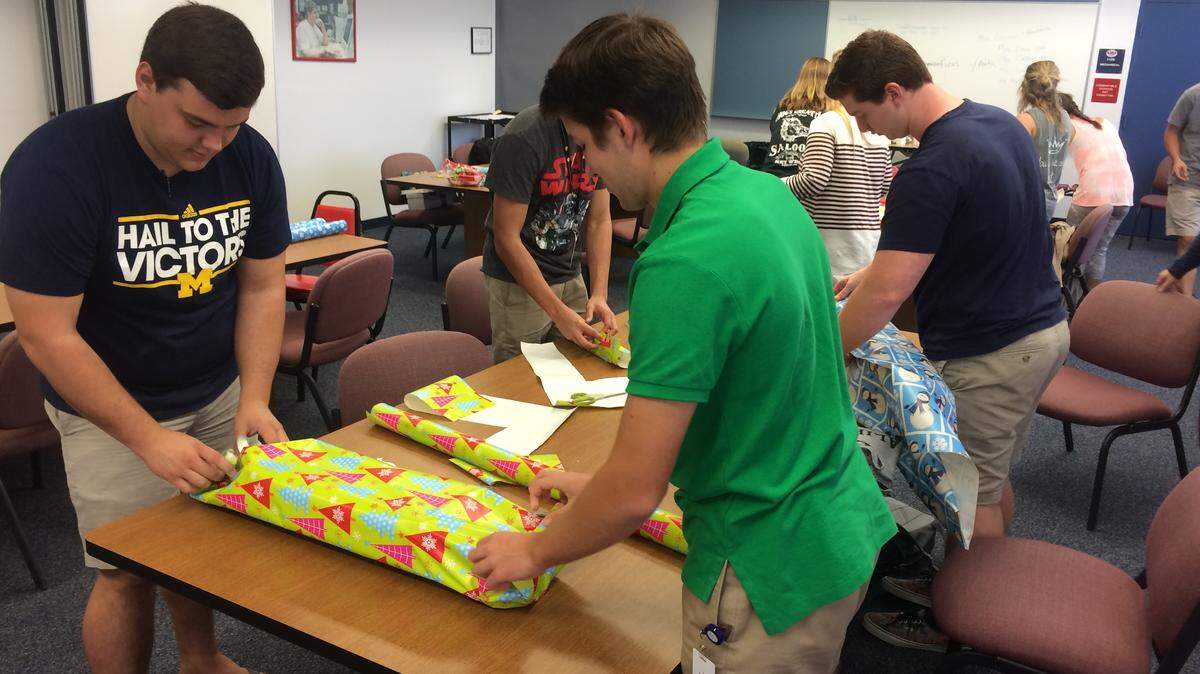 National Honor Society students at Manatee High School wrap gifts for families in need. PHOTO PROVIDED
