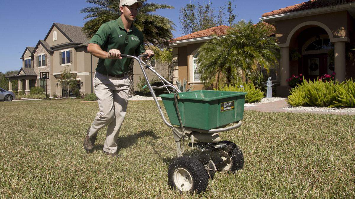 Josh Flowers, owner of Eco-Lectric Landscape Maintenance, spreads an organic fertilizer on an East Manatee lawn. U.S. Bureau of Labor Statistics show that the Bradenton-Sarasota-North Port area has the eighth highest concentration of lawn care workers in the nation. MATT M. JOHNSON/Bradenton Herald