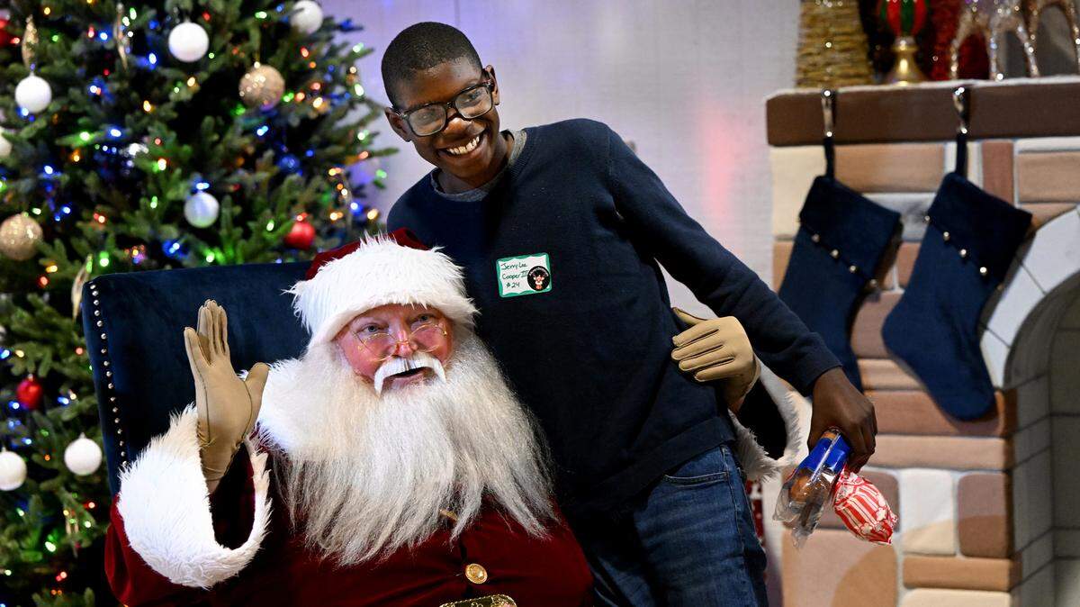 Jerry Lee Cooper III poses with Santa at the 39th Annual Flight to the North Pole program presented by the Manatee County Sheriff’s Office, Sarasota/Bradenton Airport Fire Dept. and Feld Entertainment.