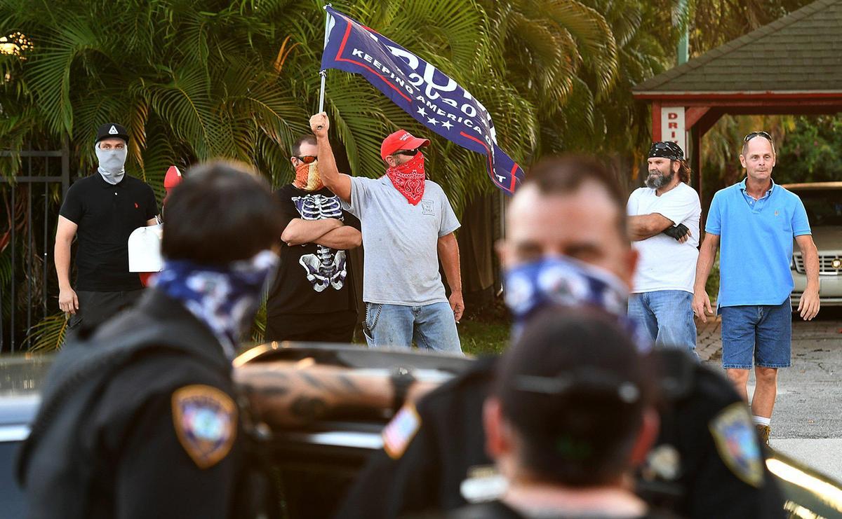 A man waves a Trump flag across the street from marchers as Bradenton Police write a ticket to a car carrying water for the marchers during a Black Lives Matter Sarasota-Manatee Alliance protest in Bradenton.