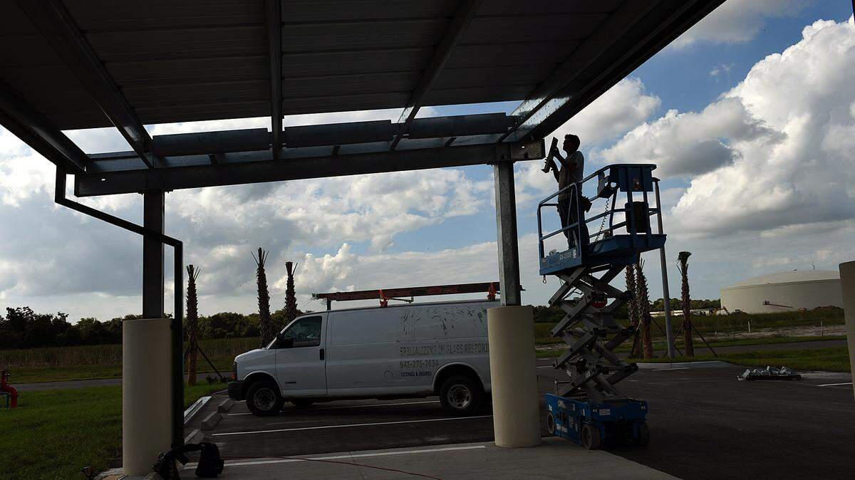 A worker finishes building a metal roof on a section of an office and lab built for Manatee County as part of the Southeast Water Reclaimation Facility complex on Lena Road. 
 TIFFANY TOMPKINS-CONDIE/Bradenton Herald