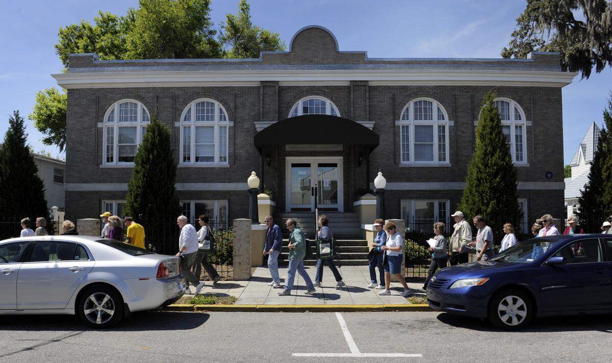 People walk past the Carnegie Library during a historic walking tour of Palmetto.