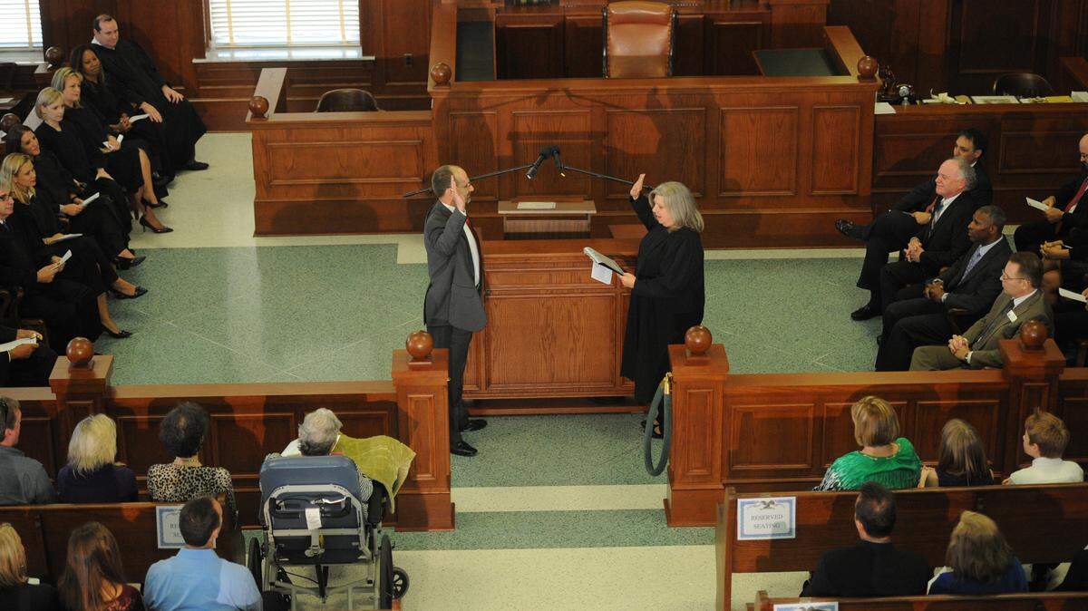 Circuit Court Judge Brian Iten is given the oath of office by Circuit Judge Janette Dunnigan at his investiture ceremony Friday at the Manatee County Historic Courtroom. 
 GRANT JEFFERIES/Bradenton Herald