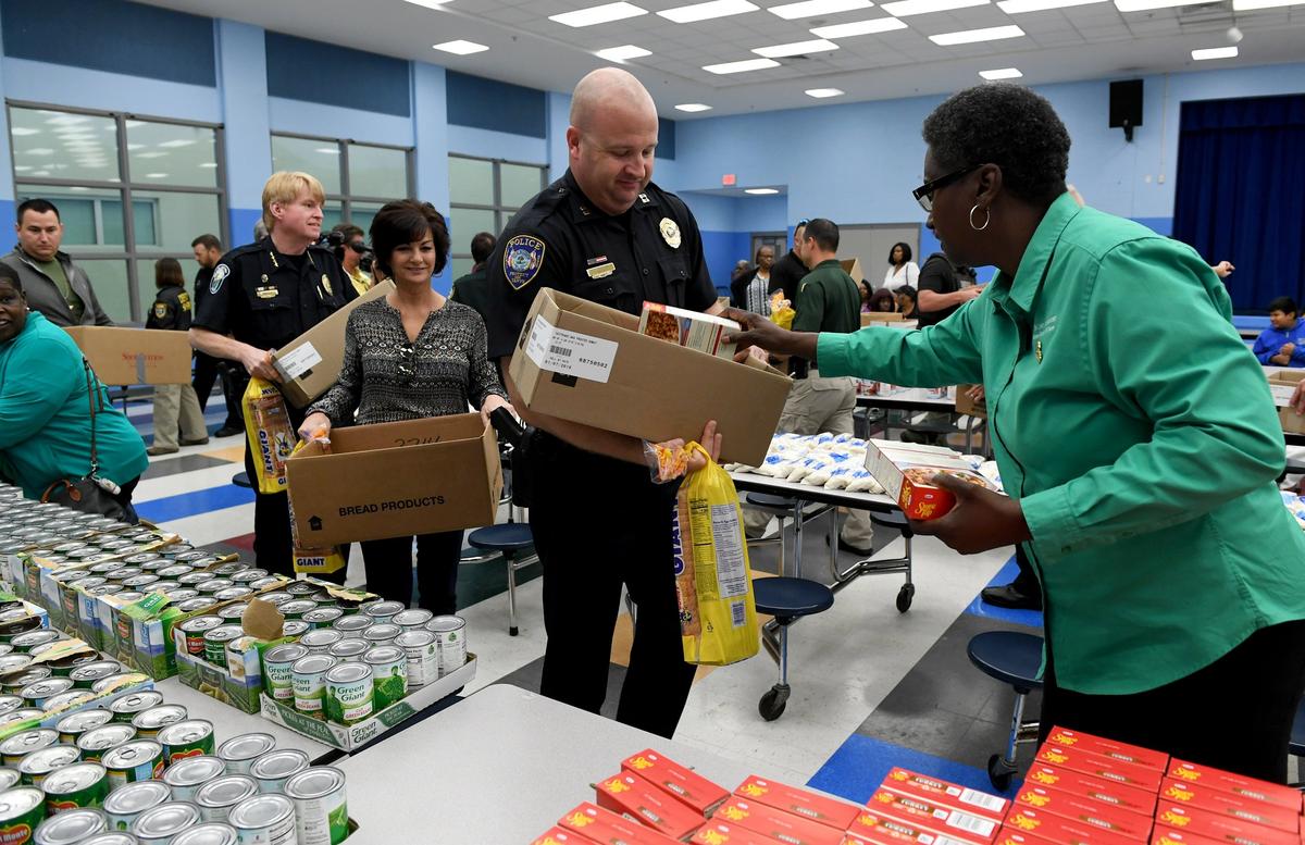 Bradenton Police Capt. Brian Thiers fills up a box of food as law enforcement participates in the 2nd Annual Sylvester Bellamy Thanksgiving Drive, putting together 200 boxes of food to distribute to the needy.
