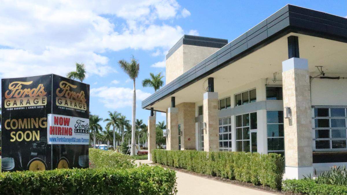 4/5/2021--Ford’s Garage is advertising outside its soon-to-open restaurant in the University Town Center location that it is hiring. Inside, antique Ford motorcars have been suspended from the ceiling.