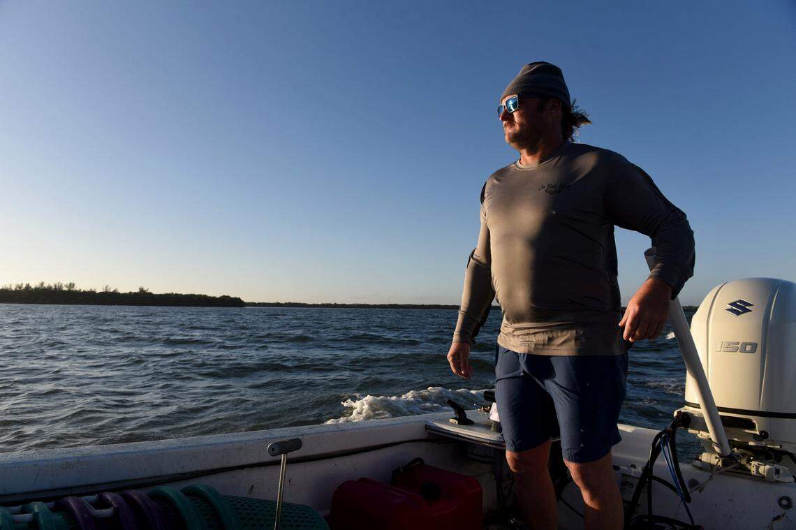 12/15/21—D.J. Strott guides his Carolina skiff through the waters of Tampa Bay to get to where his clams are growing in the shallow waters. The seedling clams are put into the shallow waters, and pulled up months later when they’re ready.