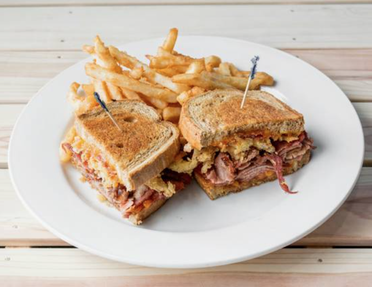 The Smokehouse, with sliced smoked brisket, cheddar cheese, barbecue sauce, fried onions, and bacon, is served on rye bread at Mila’s on the River.