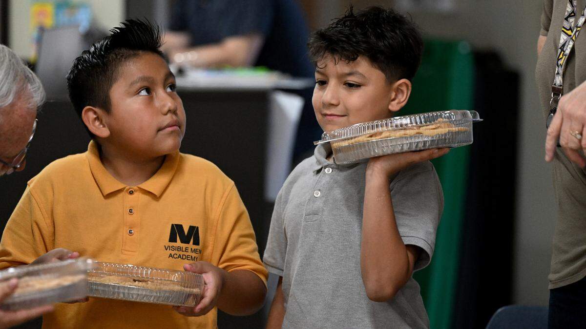 Students package the apple pies they made for their families’ Thanksgiving celebrations at Visible Men Academy on Friday, Nov. 17, 2023.