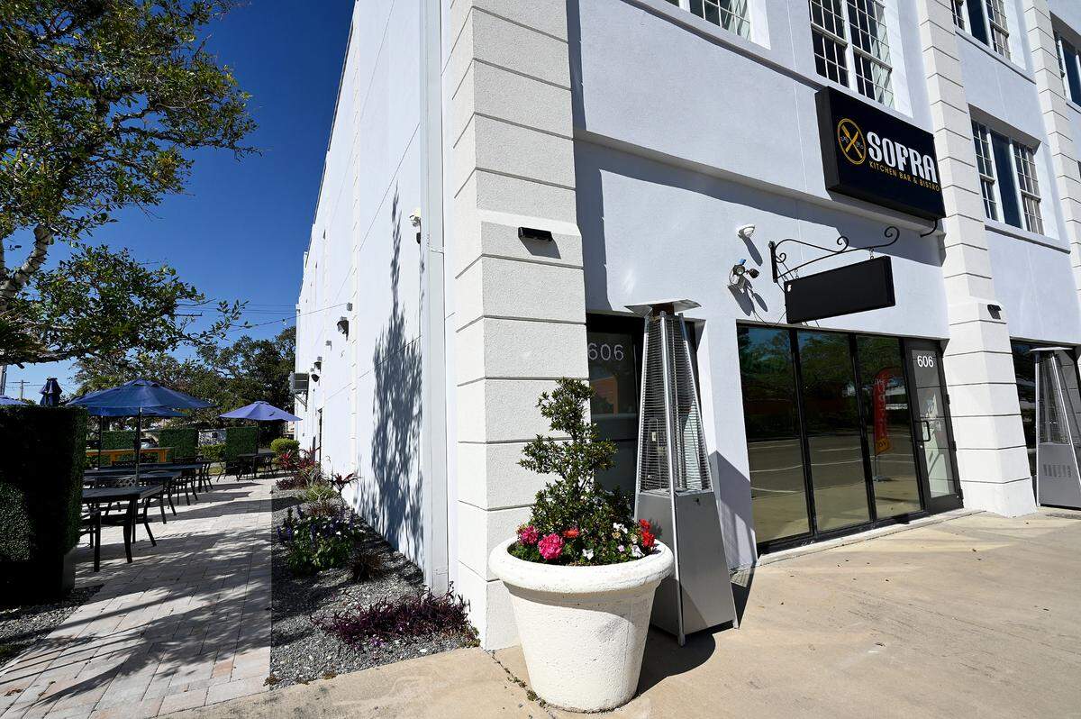 Flowers and privacy hedges surround the outdoor seating at Sofra Kitchen Bar & Bistro in downtown Bradenton.