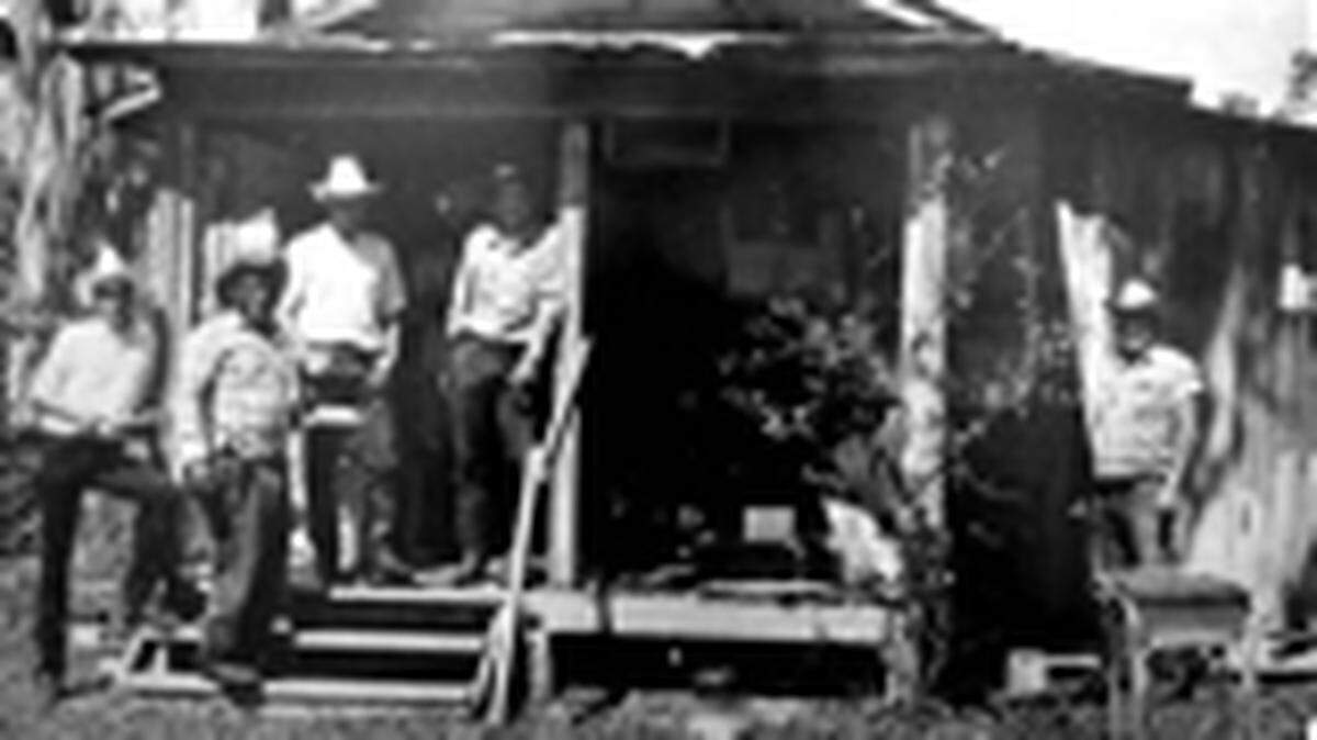 Archie Rutledge, second from left, with fellow cattlemen at a Cow Camp house on Wildes Harrison's Ranch. From left: John Harrison, Rutledge and Jeff Allday. Rear : Ellis Ballard, Clyde Ballard. Sittting: Preston Parrish. Behind post: Charley Alderman and Pee Wee Taylor. 
 Photo courtesy of Manatee County's Public Library Historic Image Digital Collection.