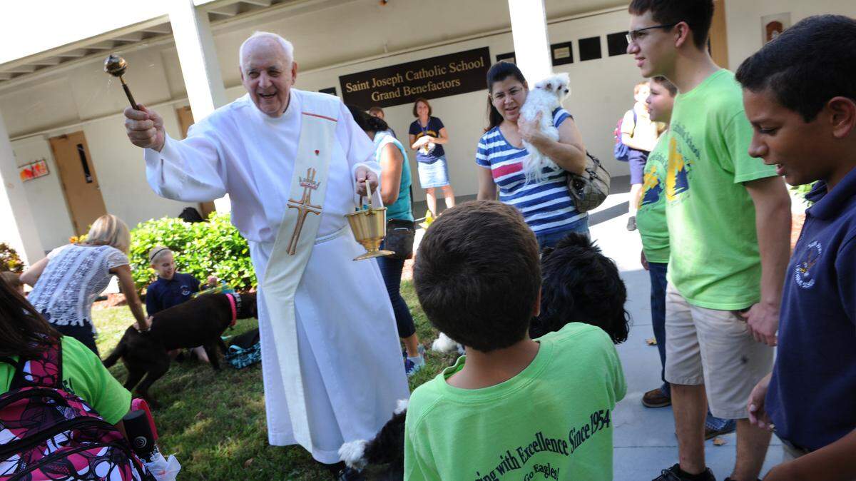 Deacon Bob Nimon smiles as he blesses the animals gathered for the Blessing of the Animals ceremony Friday at St. Joseph Catholic School. 
 GRANT JEFFERIES/Bradenton Herald