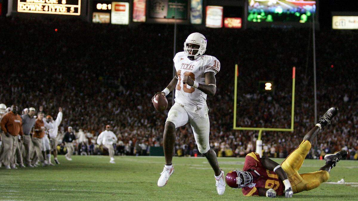 Vince Young #10 of the Texas Longhorns runs past Frostee Rucker #90 of the USC Trojans to score a touchdown and put the Longhorns up by one in the final moments of the BCS National Championship Rose Bowl Game at the Rose Bowl on January 4, 2006 in Pasadena, California.  Texas defeated USC 41-38.