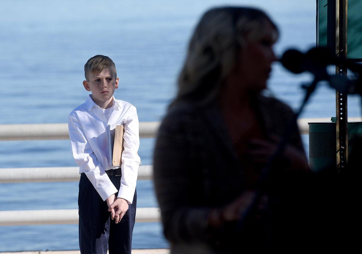 Mason Hobbs waits to read his essay to a crowd gathered to watch award winning actress and artist Jane Seymour unveil her sculpture, ‘Open Hearts’ at the Bradenton Riverwalk Friday morning.