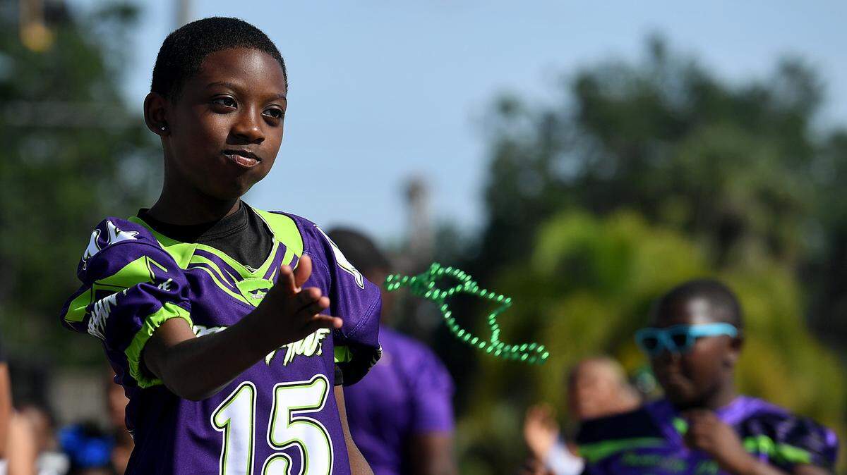 A young boy throws beads while marching with Pressure House Academy during the Hernando DeSoto Historical Society’s Children’s Parade on Friday, April 7, 2023 in Palmetto.