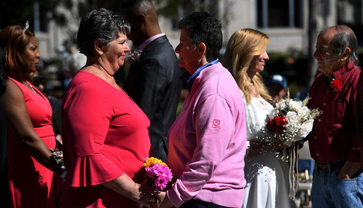 Jeanne Wheat and Michele Guillot recite their vows as couples made their relationships official during a group wedding ceremony at the Manatee County Historic courthouse’s gazebo on Feb. 14, 2022. Clerk of Court’s Angel Colonneso officiated over the ceremony.